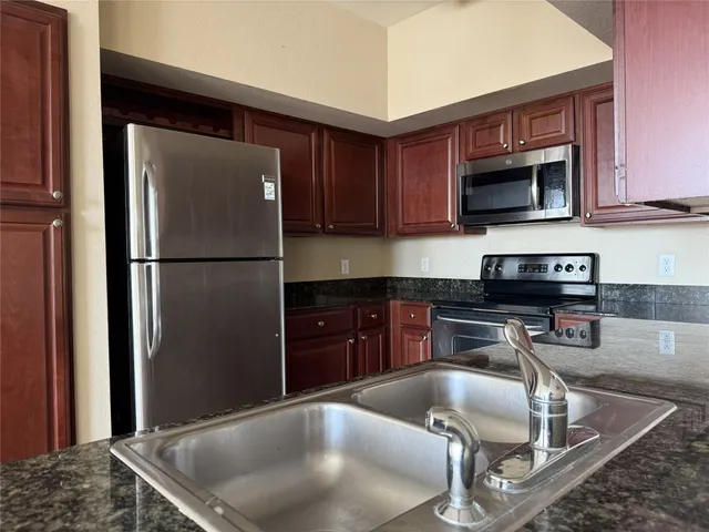 a kitchen with a sink and steel appliances