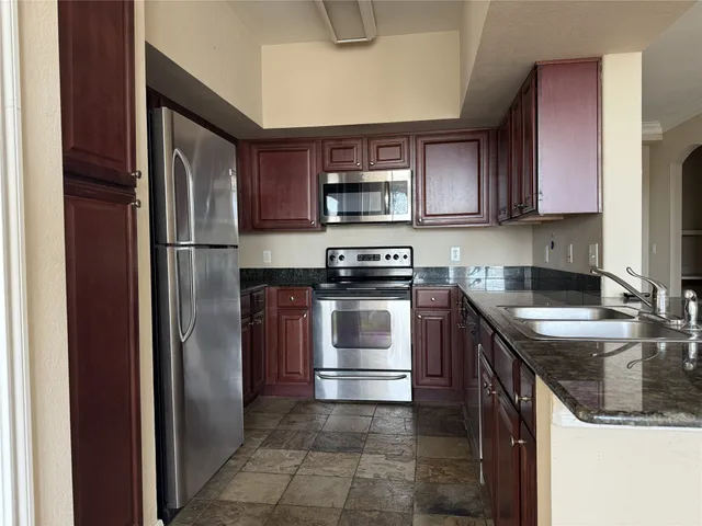 an empty room with windows and ceiling fan