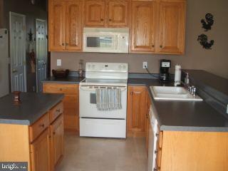 7965 Richardson Road Willards, MD 21874 - Photo 5 of 13 a kitchen with stainless steel appliances granite countertop a sink stove and refrigerator