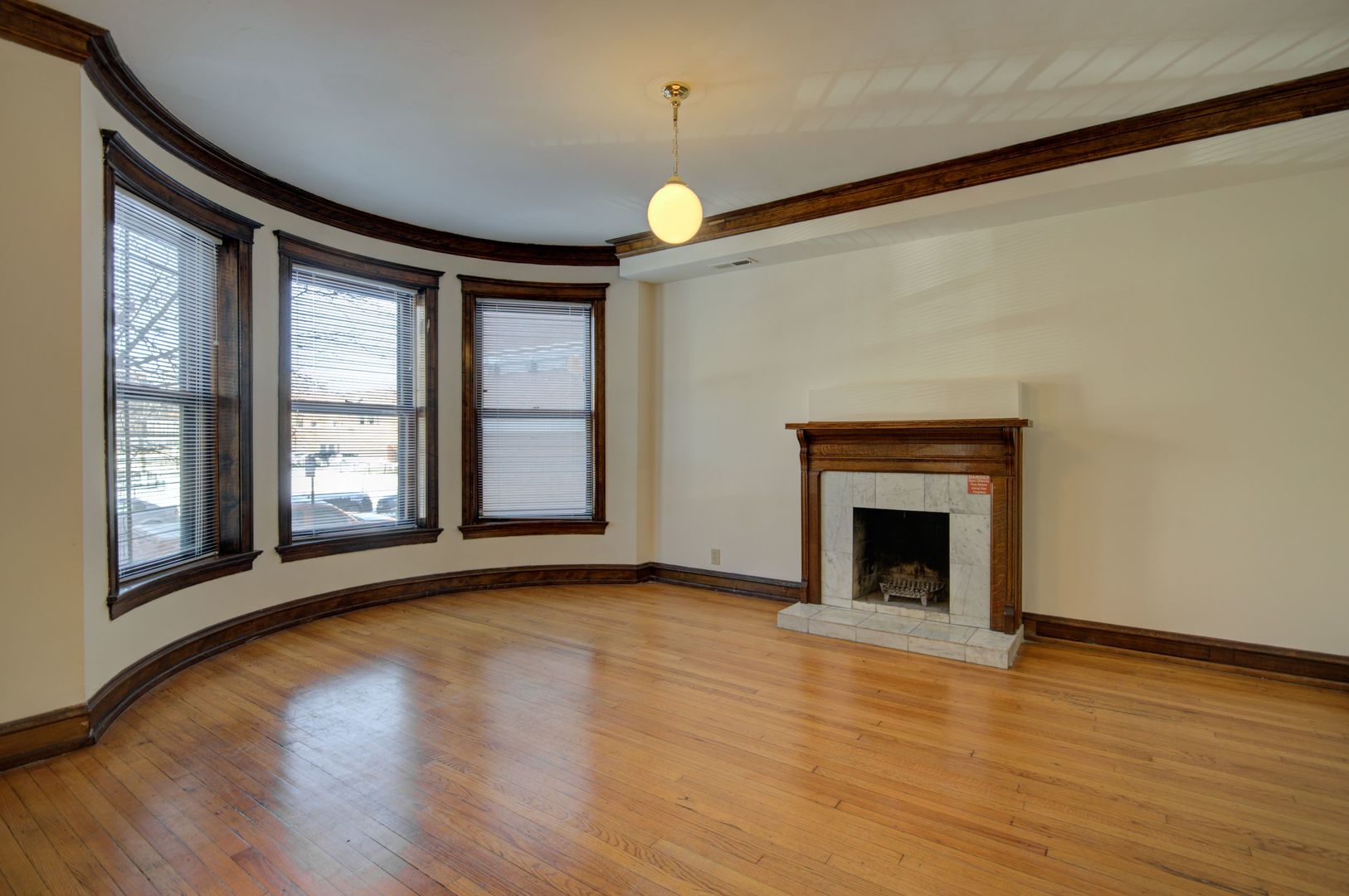 845 West Sheridan Road, Unit 1 Chicago, IL 60613 - Photo 2 of 17 a view of an empty room with wooden floor fireplace and a window