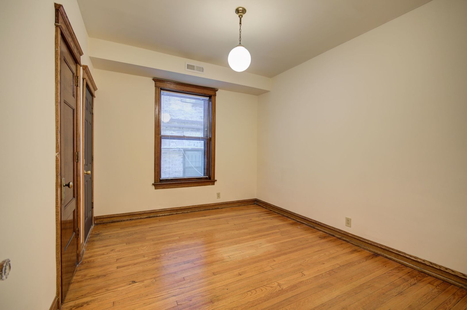 845 West Sheridan Road, Unit 1 Chicago, IL 60613 - Photo 8 of 17 a view of an empty room with wooden floor and windows