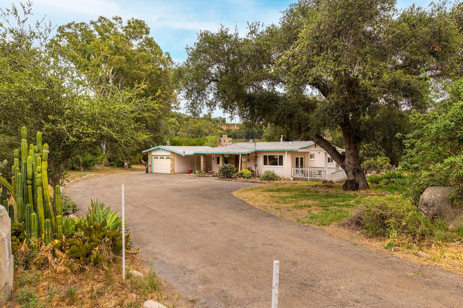 a front view of a house with a yard and trees