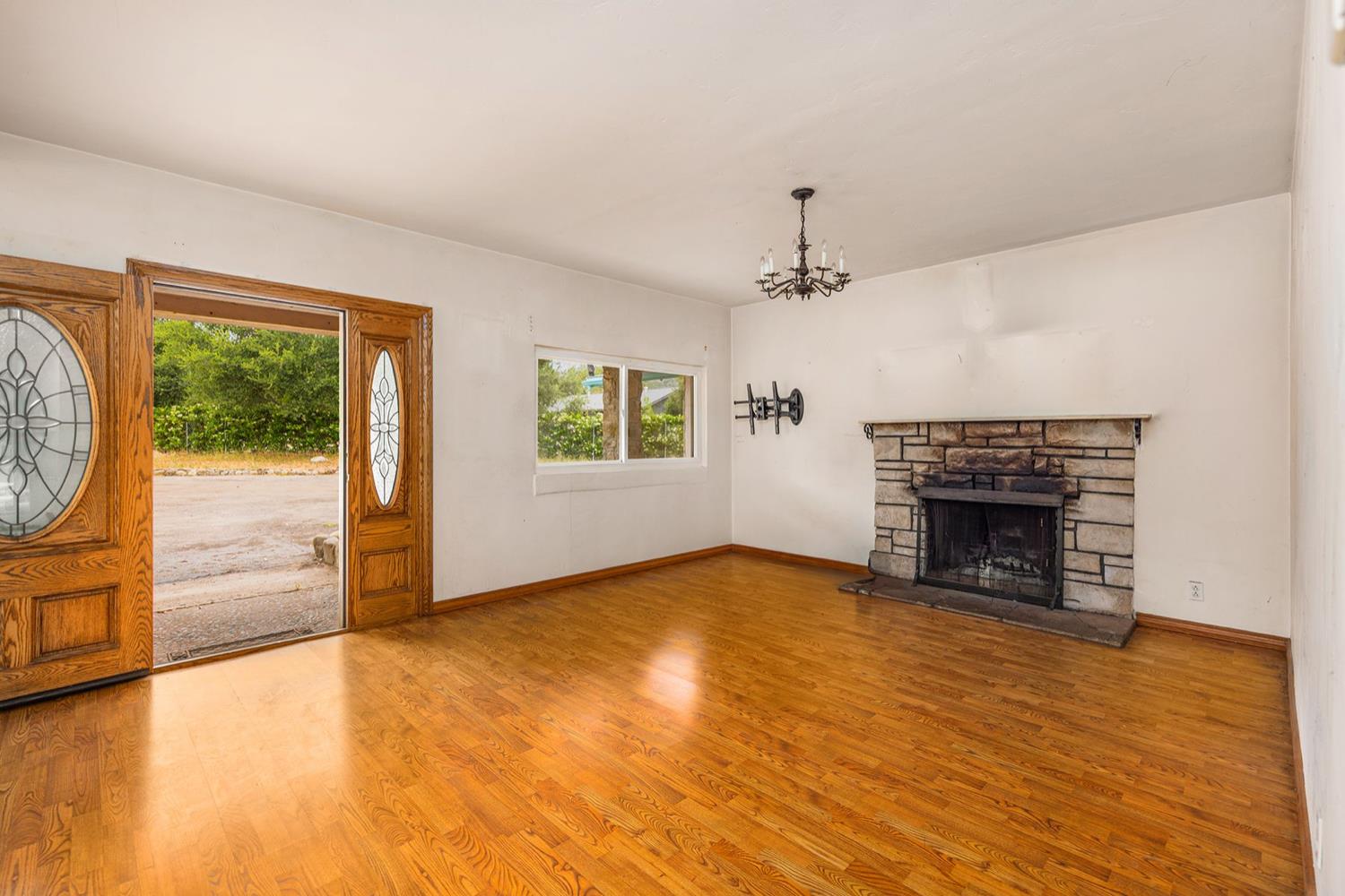 982 Oso Road Ojai, CA 93023 - Photo 10 of 21 an empty room with windows fireplace and wooden floor