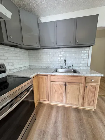 a kitchen with a sink a stove and cabinets