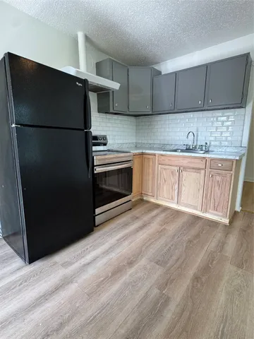 a kitchen with stainless steel appliances granite countertop a refrigerator and a sink