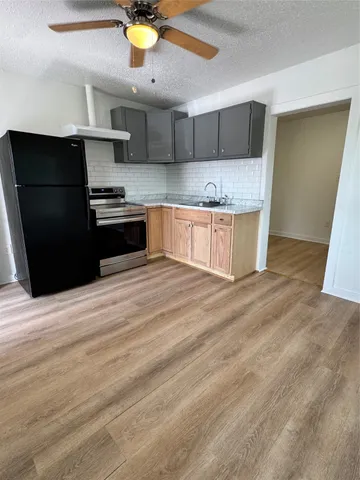 a kitchen with stainless steel appliances kitchen island granite countertop a refrigerator a sink and a stove