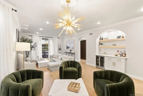 a living room with furniture a rug and kitchen view
