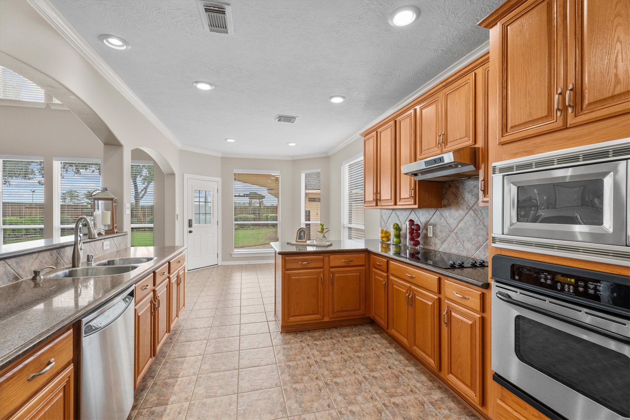 6323 Stone Trail Lane Spring, TX 77379 - Photo 9 of 43 a large kitchen with stainless steel appliances granite countertop a stove and a sink