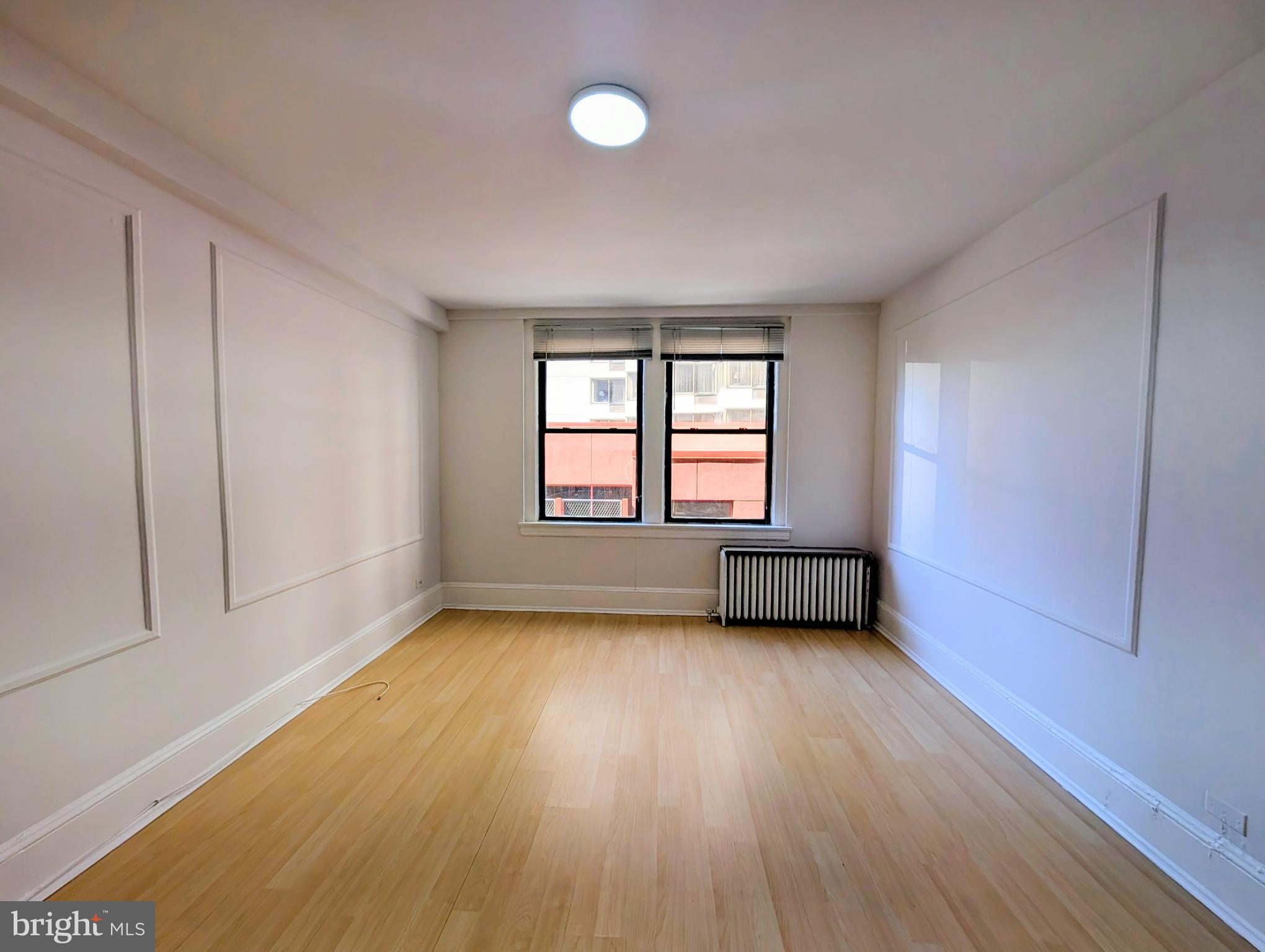 1324 Locust Street, Unit 618 Philadelphia, PA 19107 - Photo 6 of 34 an empty room with wooden floor and windows