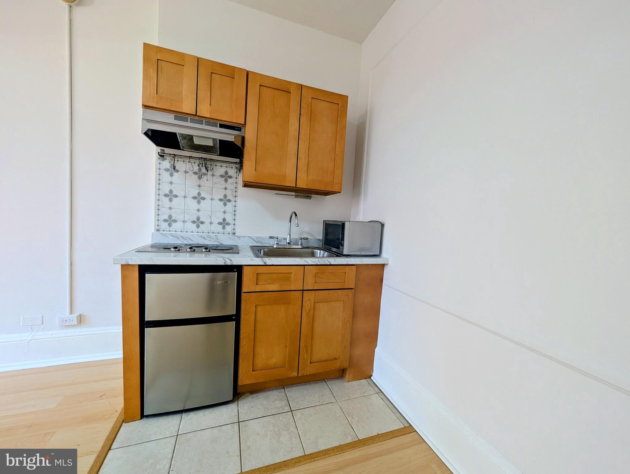 1324 Locust Street, Unit 618 Philadelphia, PA 19107 - Photo 10 of 34 a kitchen with granite countertop a sink and a stove top oven