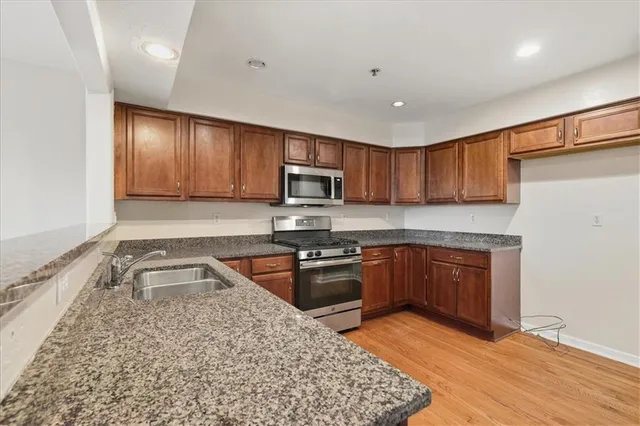 a kitchen with granite countertop wooden cabinets a stove top oven and granite counter tops