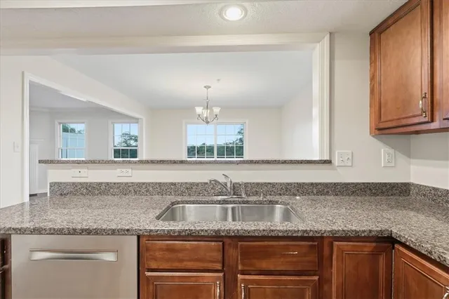 a kitchen with granite countertop a sink and cabinets