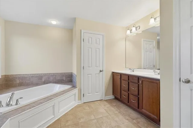 a spacious bathroom with a tub sink shower and mirror