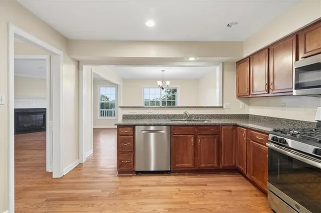 a kitchen with stainless steel appliances granite countertop a stove a sink and a microwave