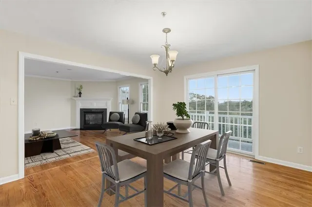 a dining room with furniture a chandelier and wooden floor