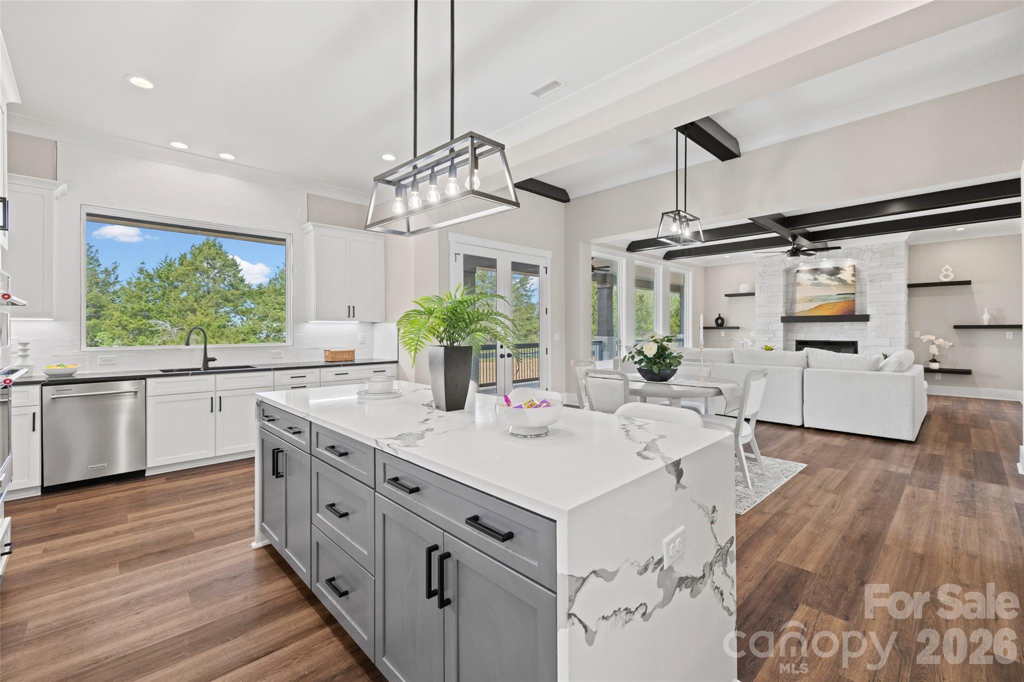 254 Triple Ponds Court Clover, SC 29710 - Photo 14 of 45 a kitchen with stainless steel appliances kitchen island granite countertop a sink dishwasher a stove and a dining table with wooden floor