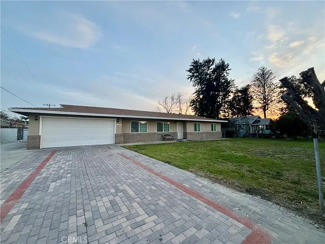 a front view of a house with a yard and trees
