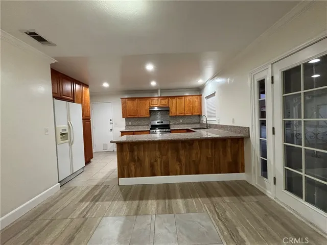a view of kitchen with refrigerator microwave and cabinets