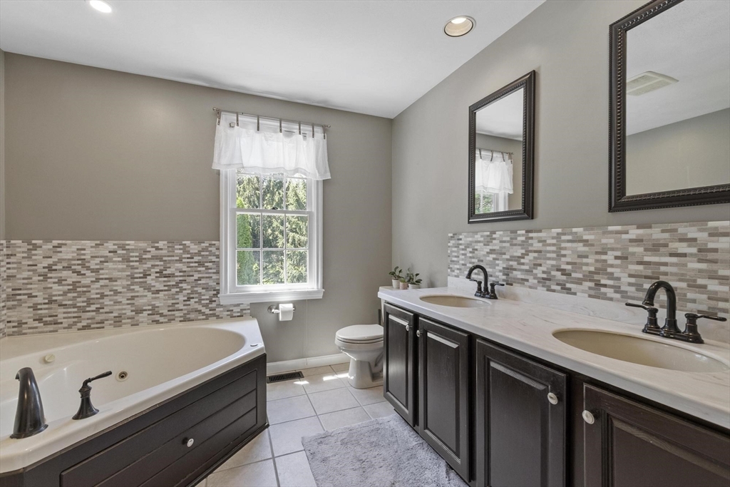 4 Ridge Road Pepperell, MA 01463 - Photo 23 of 42 a bath room with a sink a mirror and a bath tub