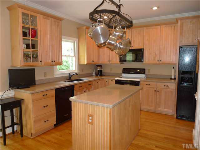 2604 Bembridge Drive Raleigh, NC 27613 - Photo 5 of 12 Updated kitchen offers silestone countertops, hardwood floors, tall maple cabinetry, black appliances, large pantry, and sunfilled casual dining area.