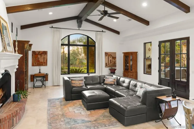 a living room with furniture fireplace and a large window