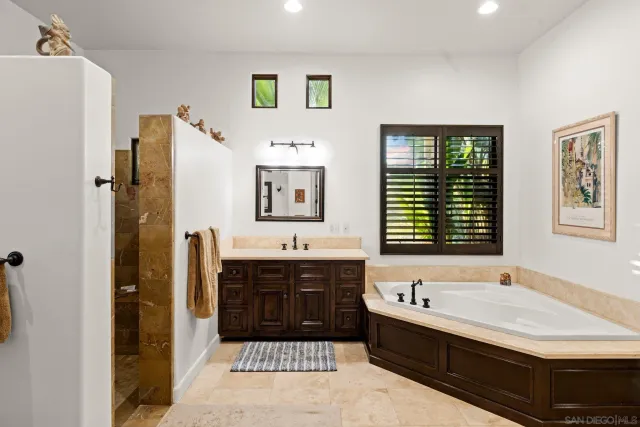 a bathroom with a tub sink and mirror