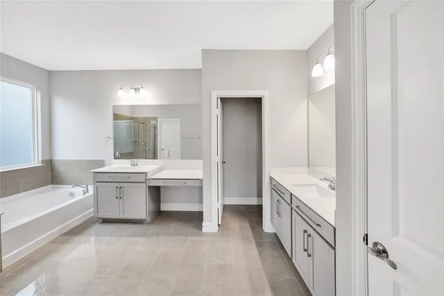 a bathroom with a tub sink shower and mirror