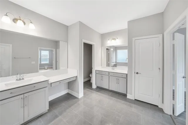 a bathroom with a double vanity sink mirror and bathtub