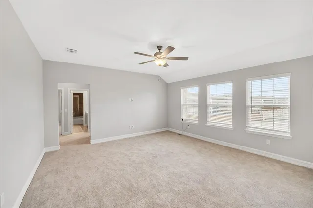 an empty room with fan and windows