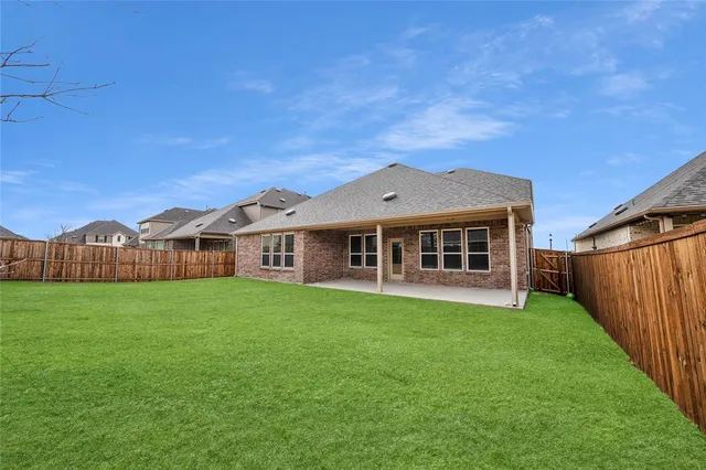 a view of a yard in front of a house with large trees