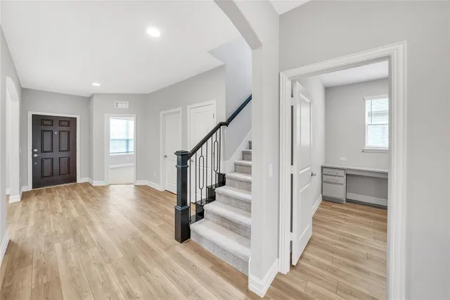 a view of a hallway with wooden floor and entryway