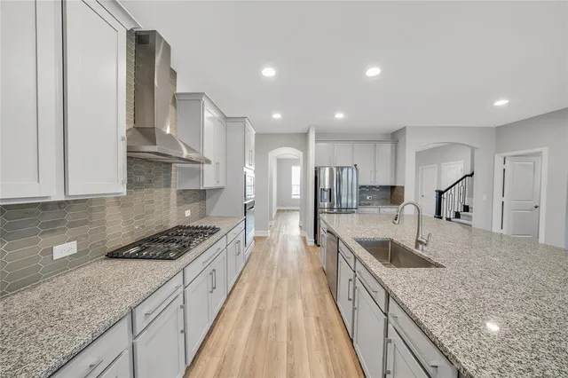 a kitchen with stainless steel appliances granite countertop a sink stove and refrigerator