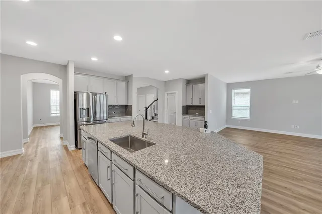 a large kitchen with kitchen island a sink stainless steel appliances and cabinets