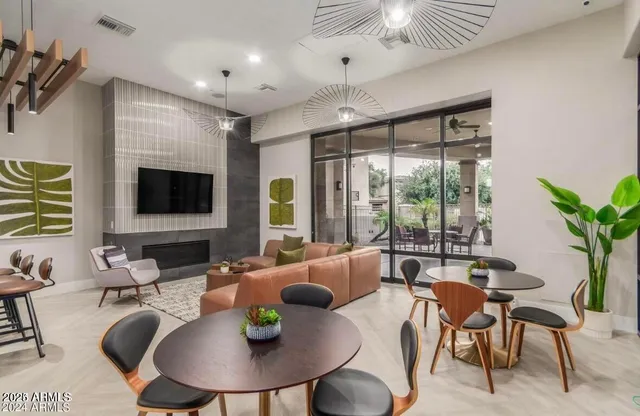 a living room with furniture a flat screen tv and a floor to ceiling window