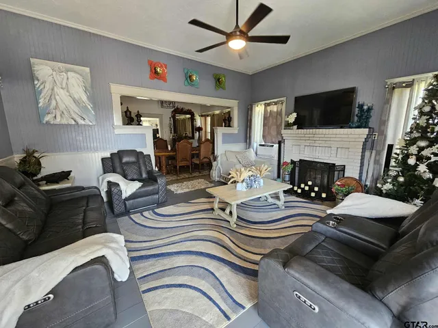a living room with furniture a fireplace and a flat screen tv