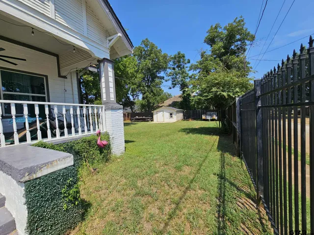 a view of a backyard with wooden fence