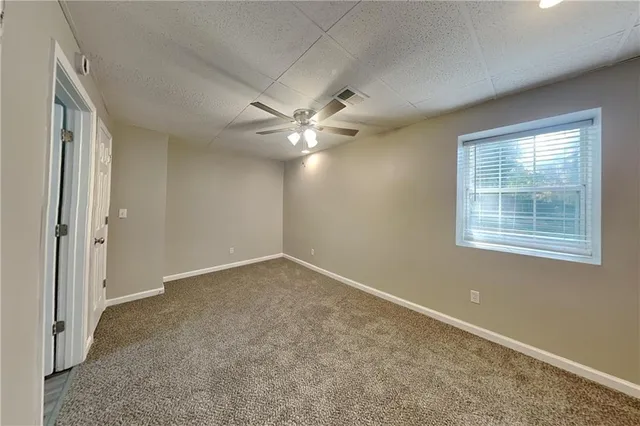 an empty room with windows and fan