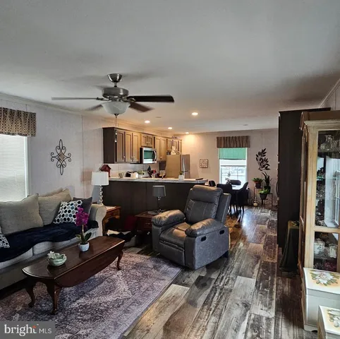 a living room with furniture kitchen view and a window
