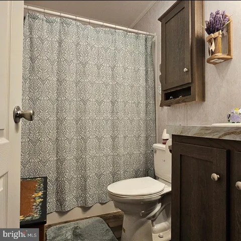 a bathroom with a toilet a sink and curtain