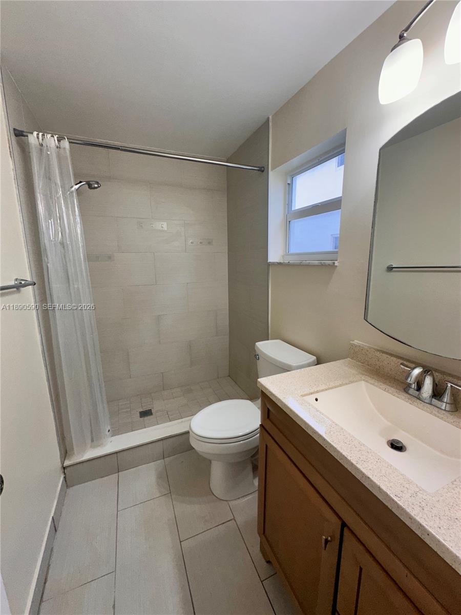 1824 Monroe Street, Unit 4 Hollywood, FL 33020 - Photo 18 of 28 a bathroom with a sink a toilet a mirror and shower