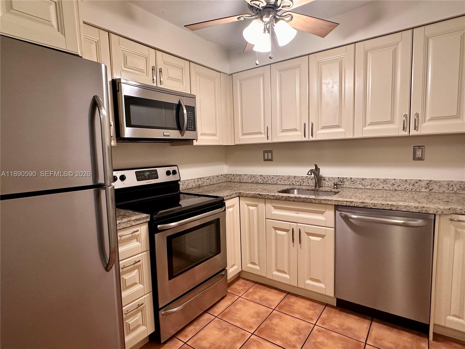1824 Monroe Street, Unit 4 Hollywood, FL 33020 - Photo 26 of 28 a kitchen with stainless steel appliances granite countertop a stove a microwave and a refrigerator