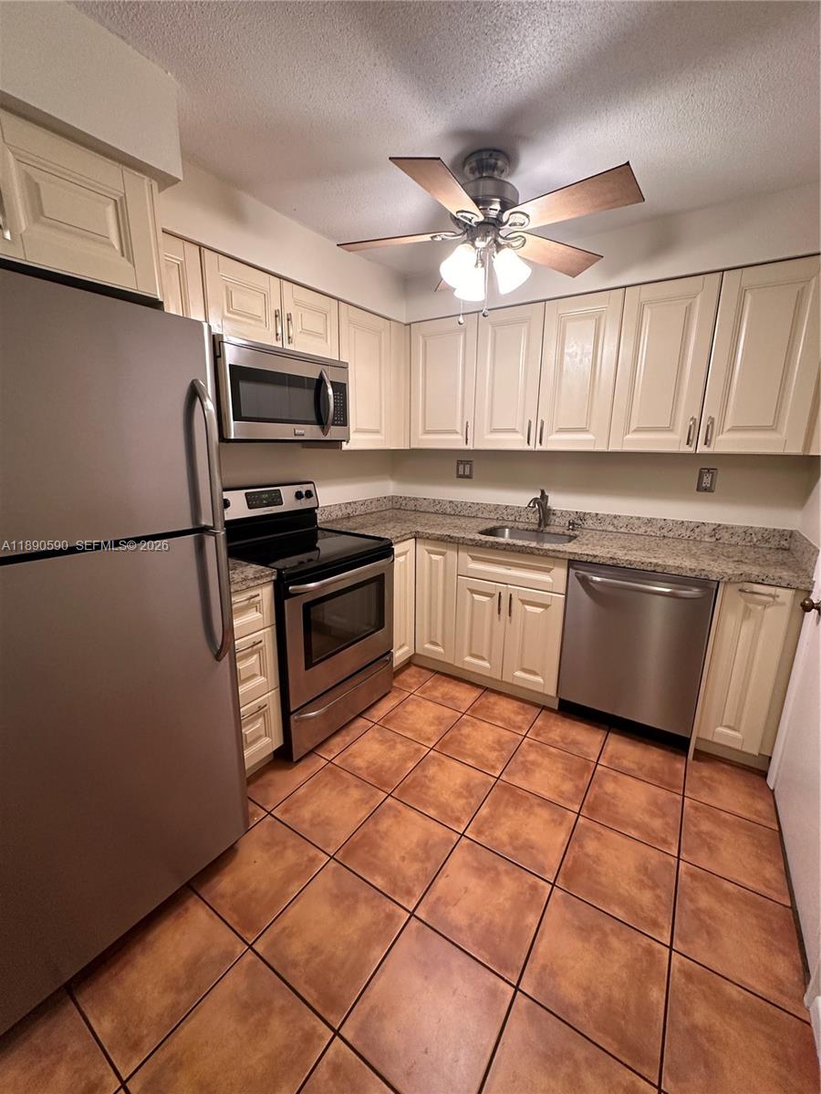 1824 Monroe Street, Unit 4 Hollywood, FL 33020 - Photo 27 of 28 a kitchen with stainless steel appliances granite countertop a sink dishwasher stove top oven and cabinets
