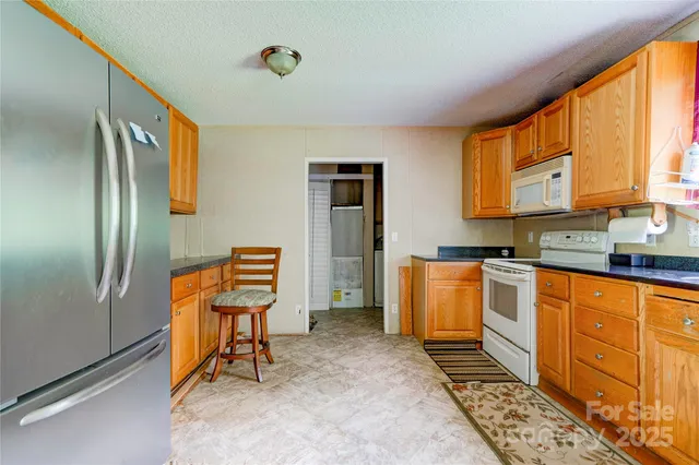 a kitchen with stainless steel appliances granite countertop a refrigerator and a stove top oven