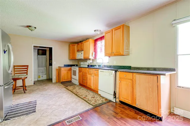a kitchen with stainless steel appliances granite countertop a refrigerator sink and cabinets