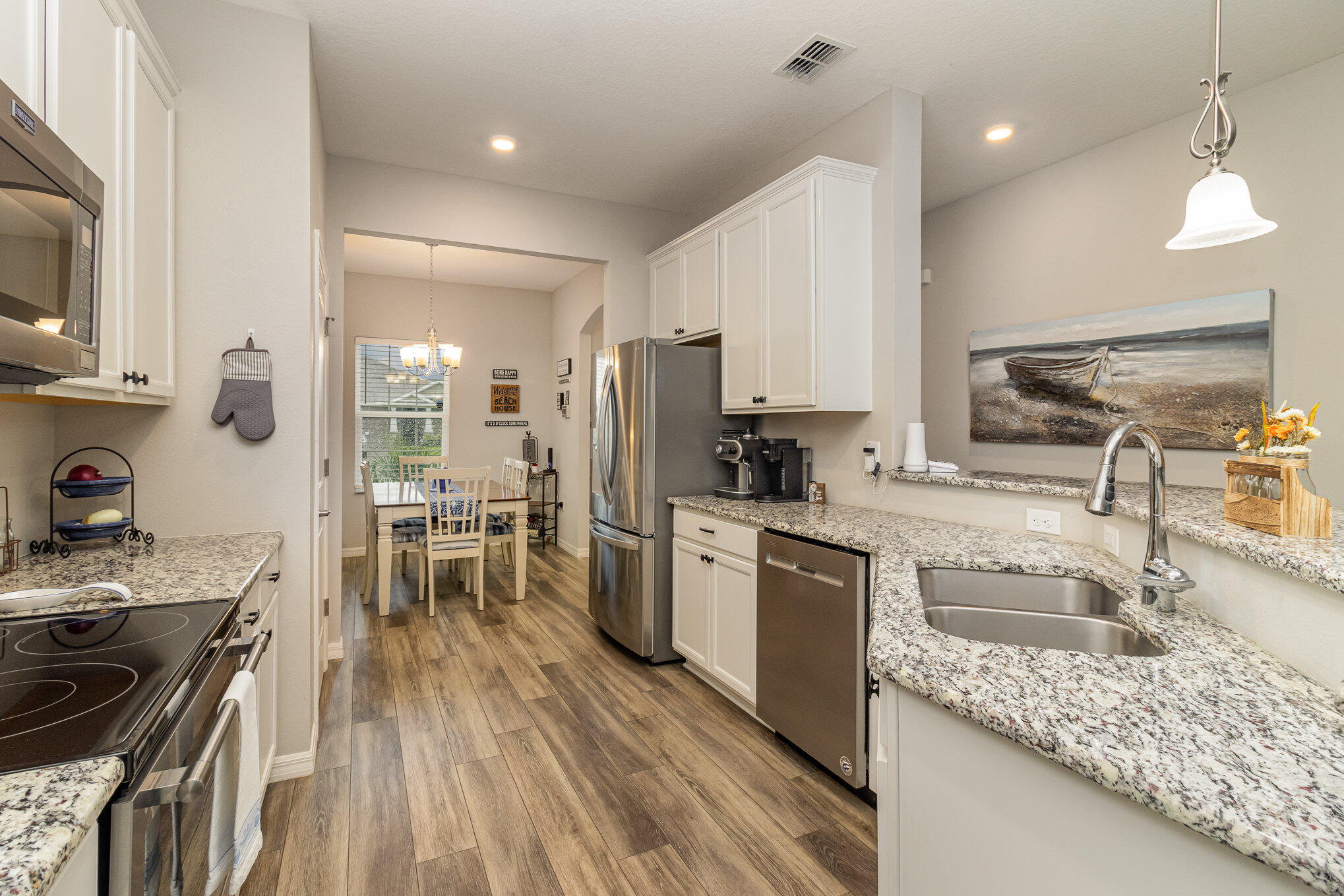 8512 Laguna Circle Micco, FL 32976 - Photo 9 of 24 a kitchen with stainless steel appliances granite countertop a sink stove and refrigerator