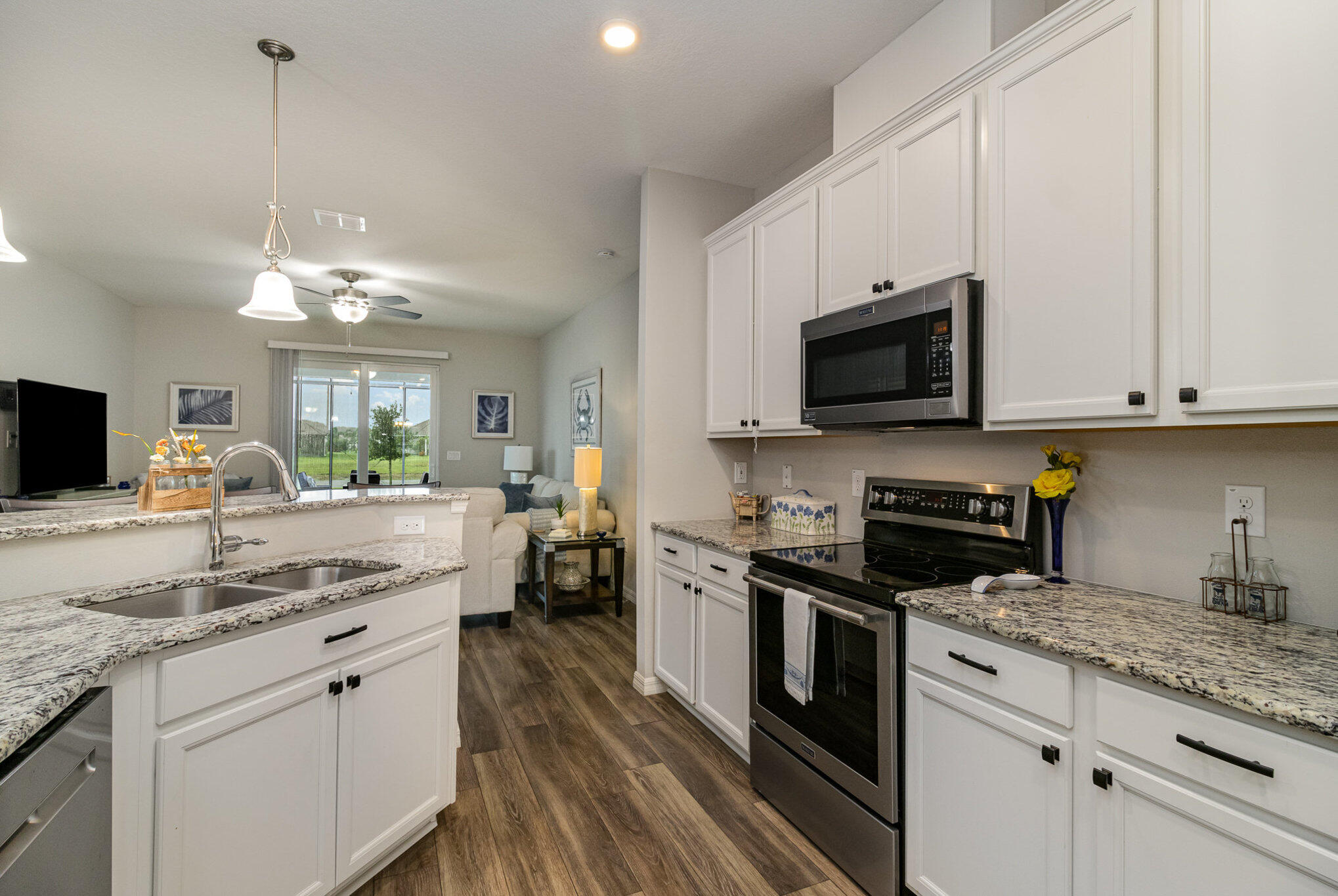 8512 Laguna Circle Micco, FL 32976 - Photo 7 of 24 a kitchen with kitchen island granite countertop stainless steel appliances a stove sink microwave and cabinets