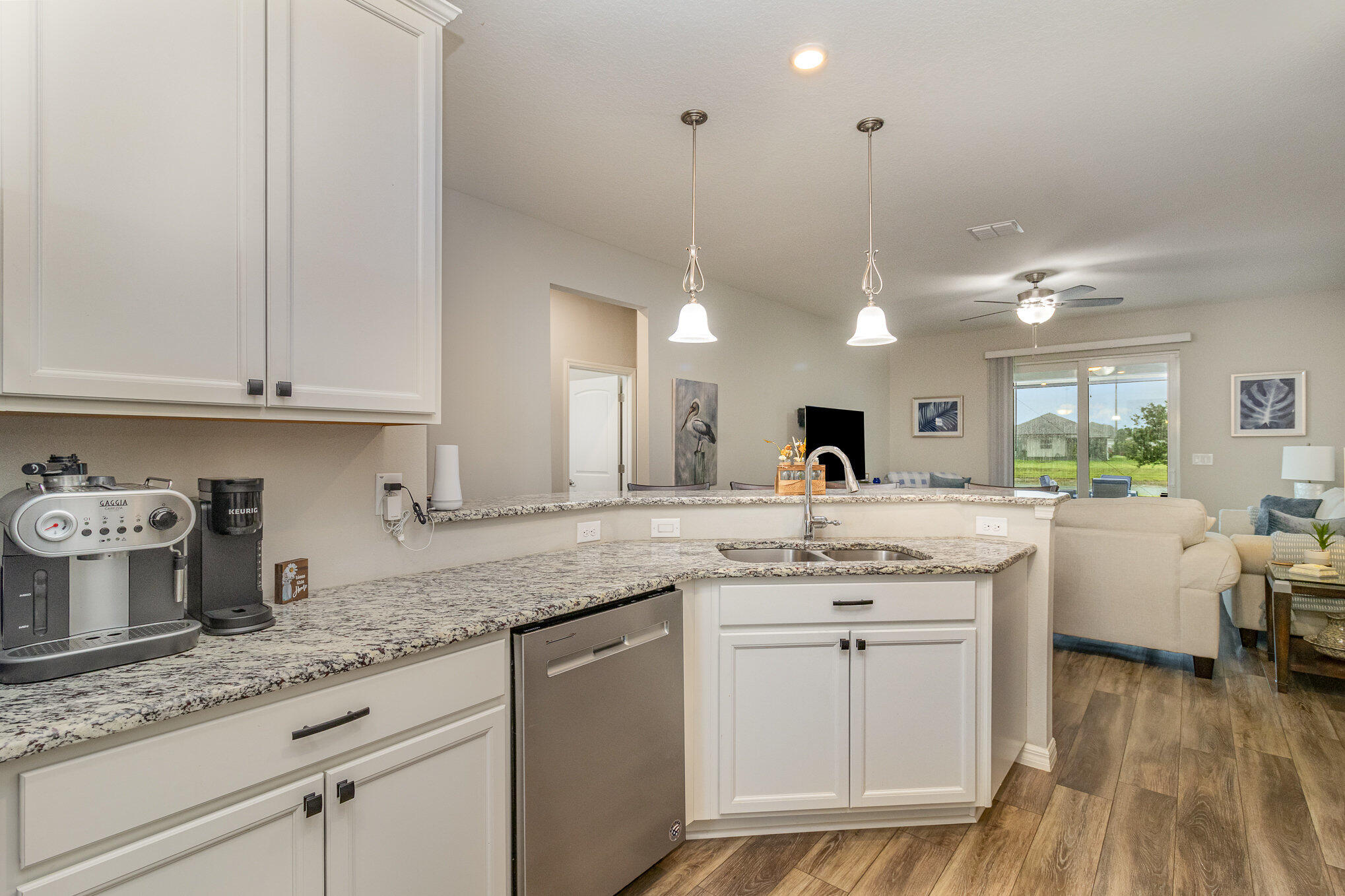 8512 Laguna Circle Micco, FL 32976 - Photo 8 of 24 a kitchen with a sink dishwasher a stove and white cabinets with wooden floor