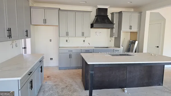 a kitchen with kitchen island granite countertop a sink stove and refrigerator