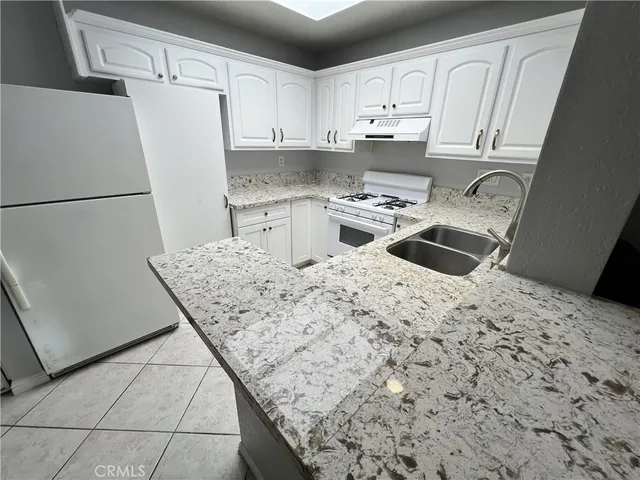 a kitchen with white cabinets and white appliances