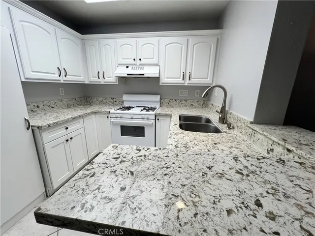 a kitchen with stainless steel appliances granite countertop a sink stove and cabinets